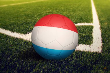 Lüksemburg bayrağı köşe vuruşu pozisyonunda, futbol sahasında. Ulusal futbol teması yeşil çimlerde.
