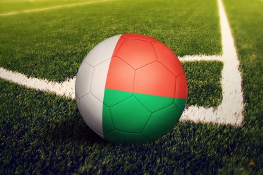 Madagaskar bayrağı köşe vuruşu pozisyonunda, futbol sahasında. Ulusal futbol teması yeşil çimlerde.
