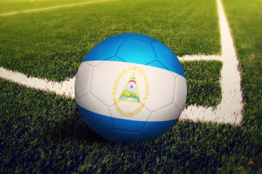 Nikaragua bayrağı köşe vuruşu pozisyonunda, futbol sahasında. Ulusal futbol teması yeşil çimlerde.