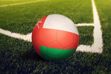 Umman bayrağı köşe vuruşunda, futbol sahasında. Ulusal futbol teması yeşil çimlerde.