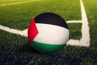Filistin bayrağı köşe vuruşu pozisyonunda, futbol sahasında. Ulusal futbol teması yeşil çimlerde.