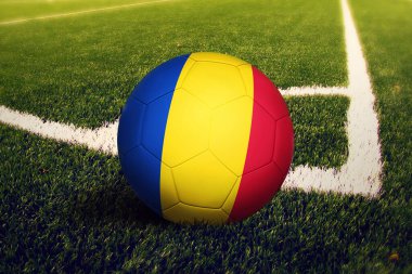 Romanya bayrağı köşe vuruşunda, futbol sahasında. Ulusal futbol teması yeşil çimlerde.