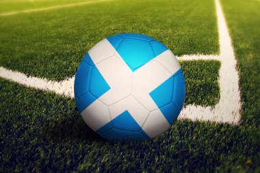 İskoçya bayrağı köşe vuruşu pozisyonunda, futbol sahasında. Ulusal futbol teması yeşil çimlerde.