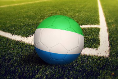 Sierra Leone bayrağı köşe vuruşu pozisyonunda, futbol sahasında. Ulusal futbol teması yeşil çimlerde.