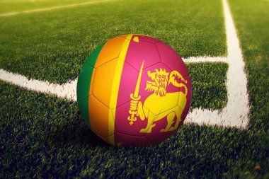 Top Sri Lanka bayrağında, köşe vuruşunda, futbol sahasında. Ulusal futbol teması yeşil çimlerde.