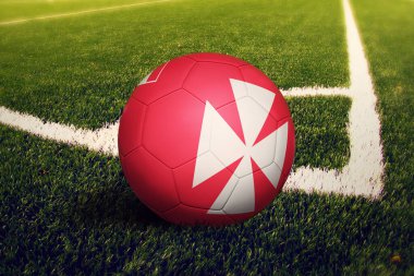 Wallis ve Futuna topu köşeye sıkıştırıyor, futbol sahasının arka planında. Ulusal futbol teması yeşil çimlerde.
