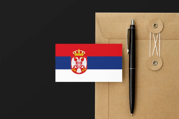 Serbia flag on craft envelope letter and black pen background. National invitation concept. Invitation for education theme.