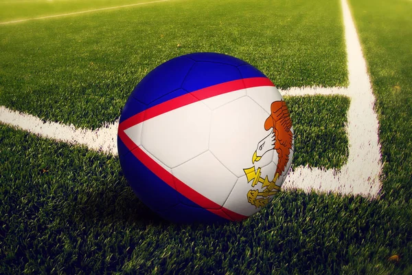 American Samoa flag on ball at corner kick position, soccer field background. National football theme on green grass.