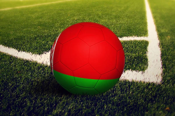 Beyaz Rusya bayrağı köşeye sıkıştı, futbol sahasının arka planında. Ulusal futbol teması yeşil çimlerde.