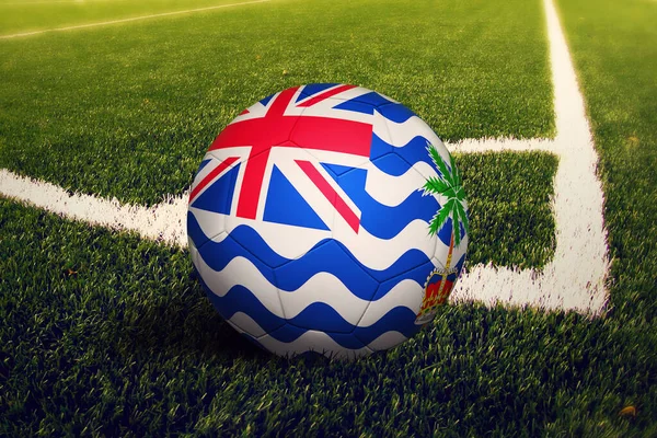 コーナーキック位置 サッカー場の背景でボールにイギリス領インド洋準州の旗 緑の草をテーマにしたサッカー日本代表 — ストック写真