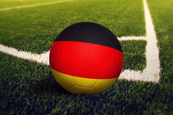 Almanya bayrağı köşe vuruşunda, futbol sahasında. Ulusal futbol teması yeşil çimlerde.