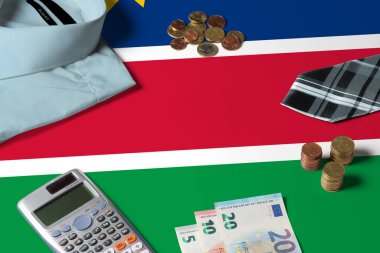 Namibya bayrağı asgari para konsepti masasında. Bayrak yüzeyinde madeni paralar ve madeni eşyalar. Ulusal ekonomi teması.