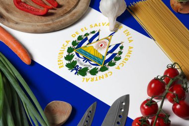 El Salvador bayrağı taze sebzeler ve bıçak kavramı ahşap masa. Arkaplan temalı aşçılık kavramı.