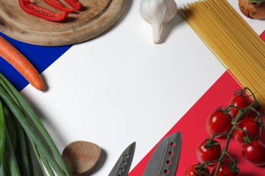 France flag on fresh vegetables and knife concept wooden table. Cooking concept with preparing background theme. clipart