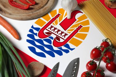 French Polynesia flag on fresh vegetables and knife concept wooden table. Cooking concept with preparing background theme. clipart