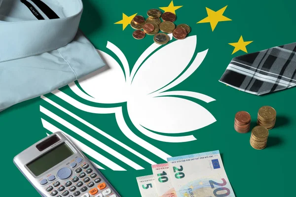 Macao flag on minimal money concept table. Coins and financial objects on flag surface. National economy theme.