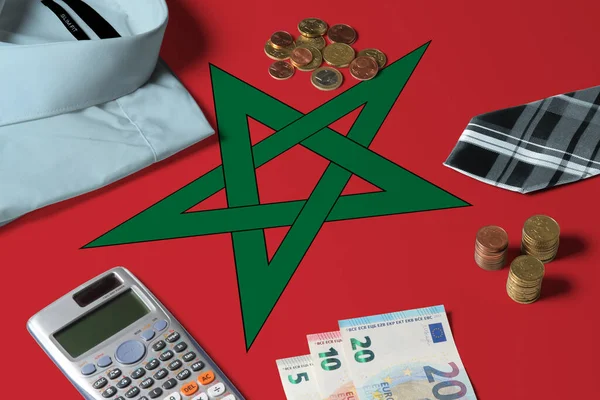 Morocco flag on minimal money concept table. Coins and financial objects on flag surface. National economy theme.