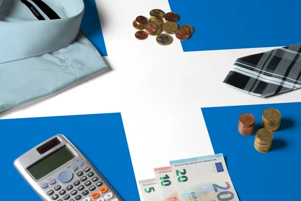 Scotland flag on minimal money concept table. Coins and financial objects on flag surface. National economy theme.