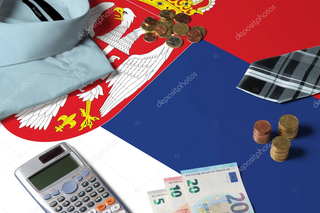 Serbia flag on minimal money concept table. Coins and financial objects on flag surface. National economy theme.