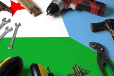 Tamir aleti kavramının tahta masa arka planında Cibuti bayrağı. Ulusal nesnelerle mekanik servis teması.