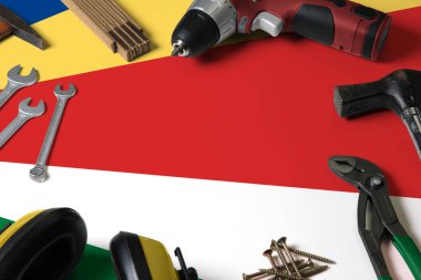 Tamir aleti kavramının tahta masa arkasında Seyşeller bayrağı. Ulusal nesnelerle mekanik servis teması.