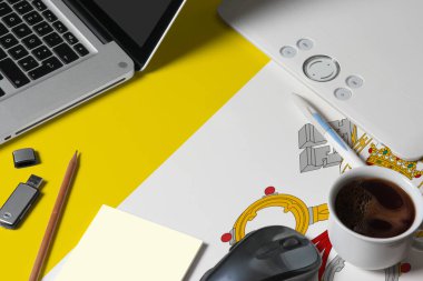 Vatikan ulusal bayrağı en üstte dizüstü bilgisayarı, klavyesi, usb sürücüsü, grafik tableti, kahve fincanı, ahşap masadaki fare yaratıcı tasarımcının çalışma alanı.