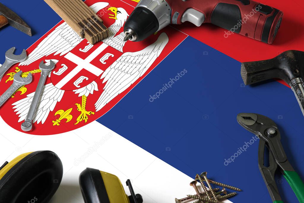 Serbia flag on repair tool concept wooden table background. Mechanical service theme with national objects.