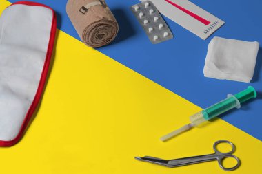 Ahşap masa arkasında ilk yardım çantasıyla Ukrayna bayrağı. Ulusal sağlık sistemi konsepti, tıbbi tema.