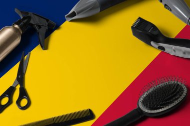 Saç kesme aletli Chad bayrağı. Ulusal bir ahşap arka planda güzellik salonunun masasında taraklar, makas ve kuaför aletleri.