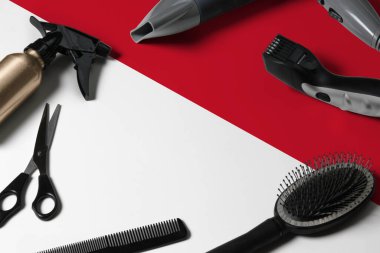 Saç kesme aletli Endonezya bayrağı. Ulusal bir ahşap arka planda güzellik salonunun masasında taraklar, makas ve kuaför aletleri.