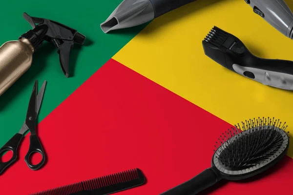 Benin flag with hair cutting tools. Combs, scissors and hairdressing tools in a beauty salon desktop on a national wooden background.