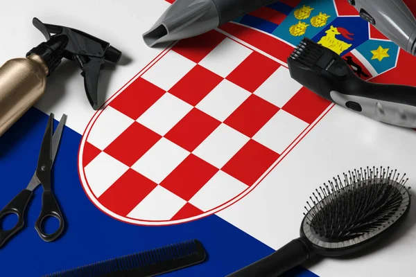 Croatia flag with hair cutting tools. Combs, scissors and hairdressing tools in a beauty salon desktop on a national wooden background.