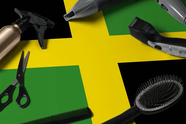 Jamaica flag with hair cutting tools. Combs, scissors and hairdressing tools in a beauty salon desktop on a national wooden background.