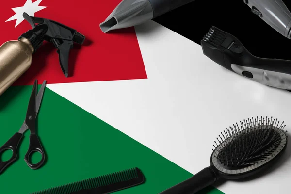 Jordan flag with hair cutting tools. Combs, scissors and hairdressing tools in a beauty salon desktop on a national wooden background.