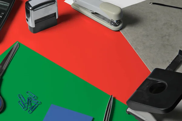 Oman flag with office clerk workplace background. National stationary concept with office tools.