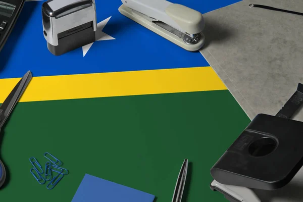 Solomon Islands flag with office clerk workplace background. National stationary concept with office tools.