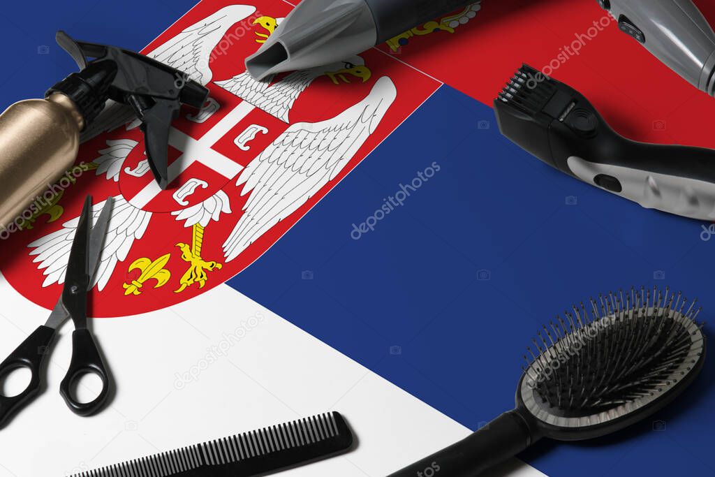 Serbia flag with hair cutting tools. Combs, scissors and hairdressing tools in a beauty salon desktop on a national wooden background.