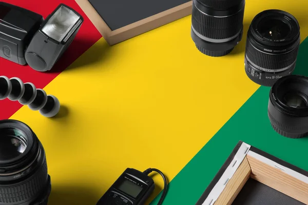 白い木製のテーブルの上に個人的な写真家の機器やツールのトップビューでギニアビサウ国旗 コピースペース — ストック写真