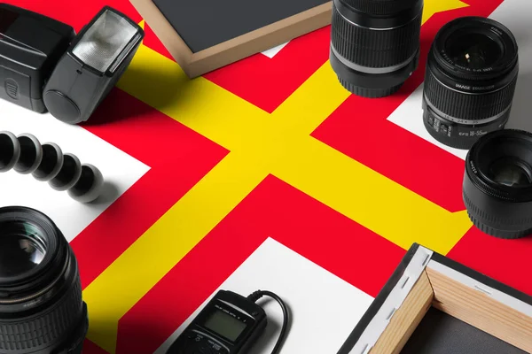白い木製のテーブルの上に個人的な写真家の機器やツールのトップビューでガーンジー国旗 コピースペース — ストック写真