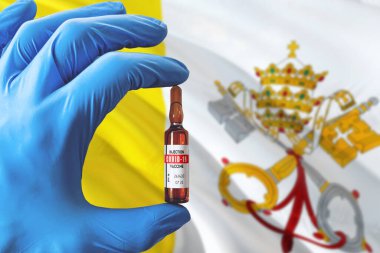 Coronavirus Covid-19 konseptli Vatikan bayrağı. Mavi koruma eldivenli doktor elinde aşı şişesi tutuyor. Salgın virüsü, Cov-19, Corona virüsü salgını.