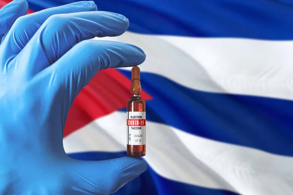 Cuba flag with Coronavirus Covid-19 concept. Doctor with blue protection medical gloves holding a vaccine bottle. Epidemic Virus, Cov-19, Corona virus outbreaking.