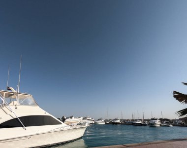 Kızıl Deniz manzarası ve beyaz yatlar. Mısır Hurghada. Tekneler, kıyıya demir atmış gemiler. İskele, iskele. Deniz kenarında yaz ve dinlenme