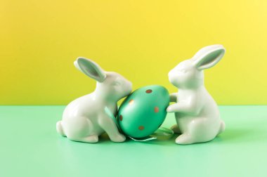 Parlak arka planda tavşan heykelcikli yumurta. Kuş benekli yumurta. Birkaç nesne. Sağlıklı yiyecekler. Paskalya tatili