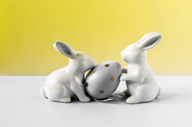 Parlak arka planda tavşan heykelcikli yumurta. Kuş benekli yumurta. Birkaç nesne. Sağlıklı yiyecekler. Paskalya tatili