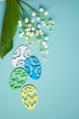 Çiçek mavisi arka plan ve taze çiçekler. Paskalya için bahar tebrik kartı. Bir buket nilüfer çiçeği ve bir hediye, yumurta..