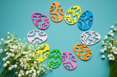 Çiçek mavisi arka plan ve taze çiçekler. Paskalya için bahar tebrik kartı. Bir buket nilüfer çiçeği ve bir hediye, yumurta..