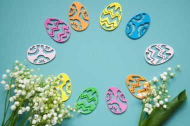 Çiçek mavisi arka plan ve taze çiçekler. Paskalya için bahar tebrik kartı. Bir buket nilüfer çiçeği ve bir hediye, yumurta..