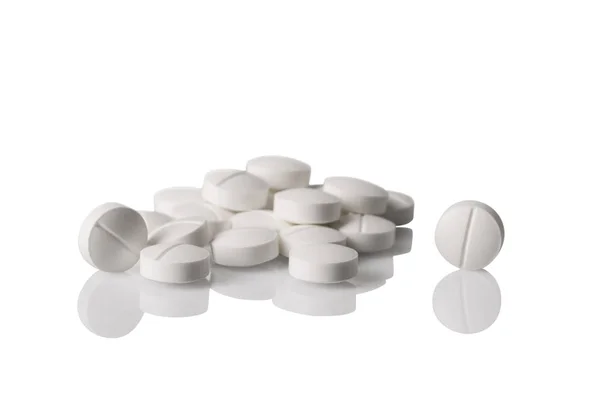 White pills on counter with reflection — Stock Photo, Image