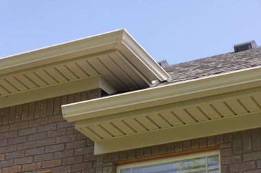 Çatı olukları ve recessed bir tuğla ev arkasında gösterilen.