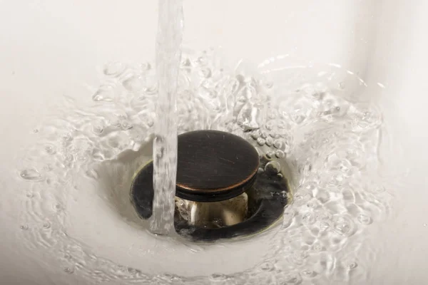 stock image Water going down sink drain
